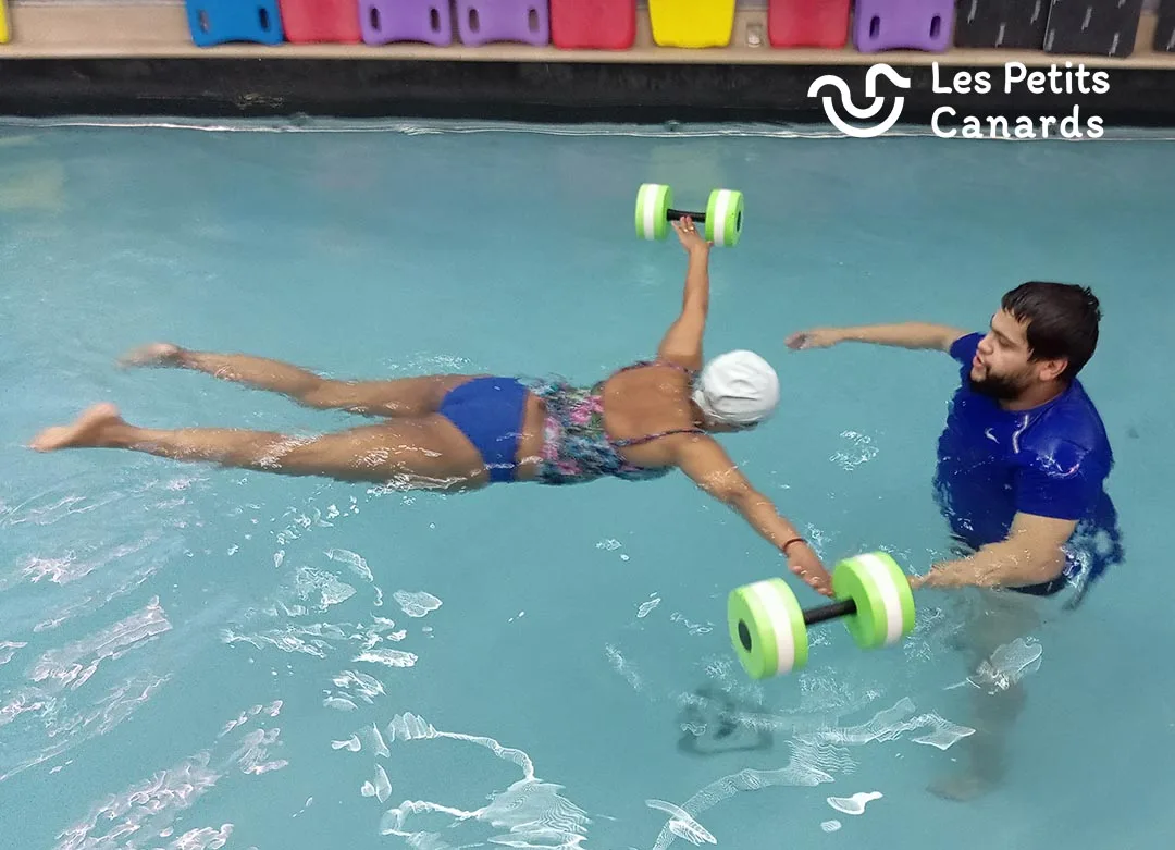 adulte apprend a nager avec les petits canarads